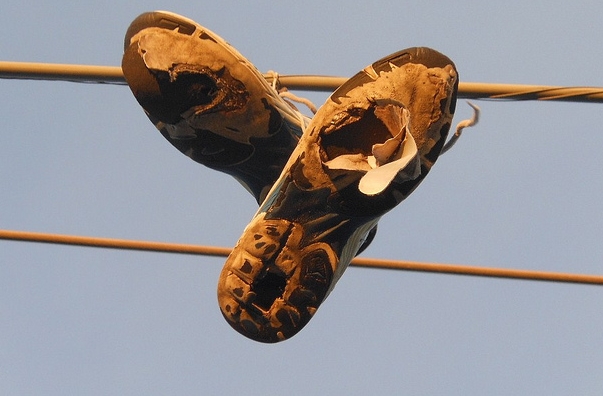 hier-hängen-schuhe-mit-loechern-von-einem-telefonmast