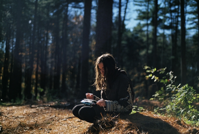 hier-schreibt-ein-maedchen-im-wald-in-einen-block