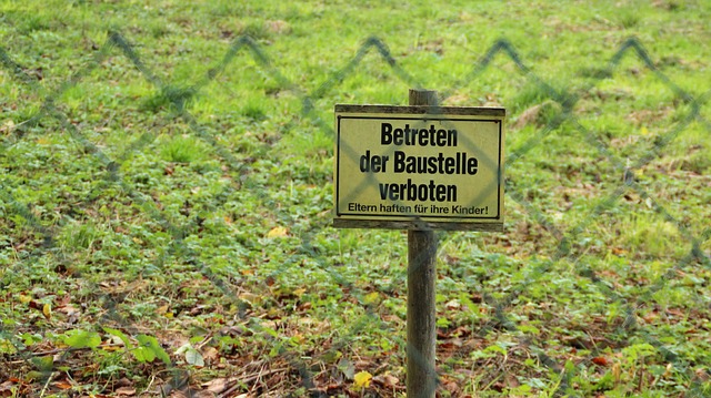 Schild hinter Zaun Betreten der Baustelle verboten
