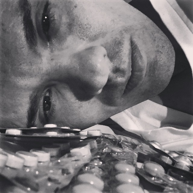 trauriger Mann mit Tabletten im Vordergrund