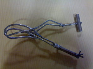 Das's long curved delivery forceps with axis traction devices in place